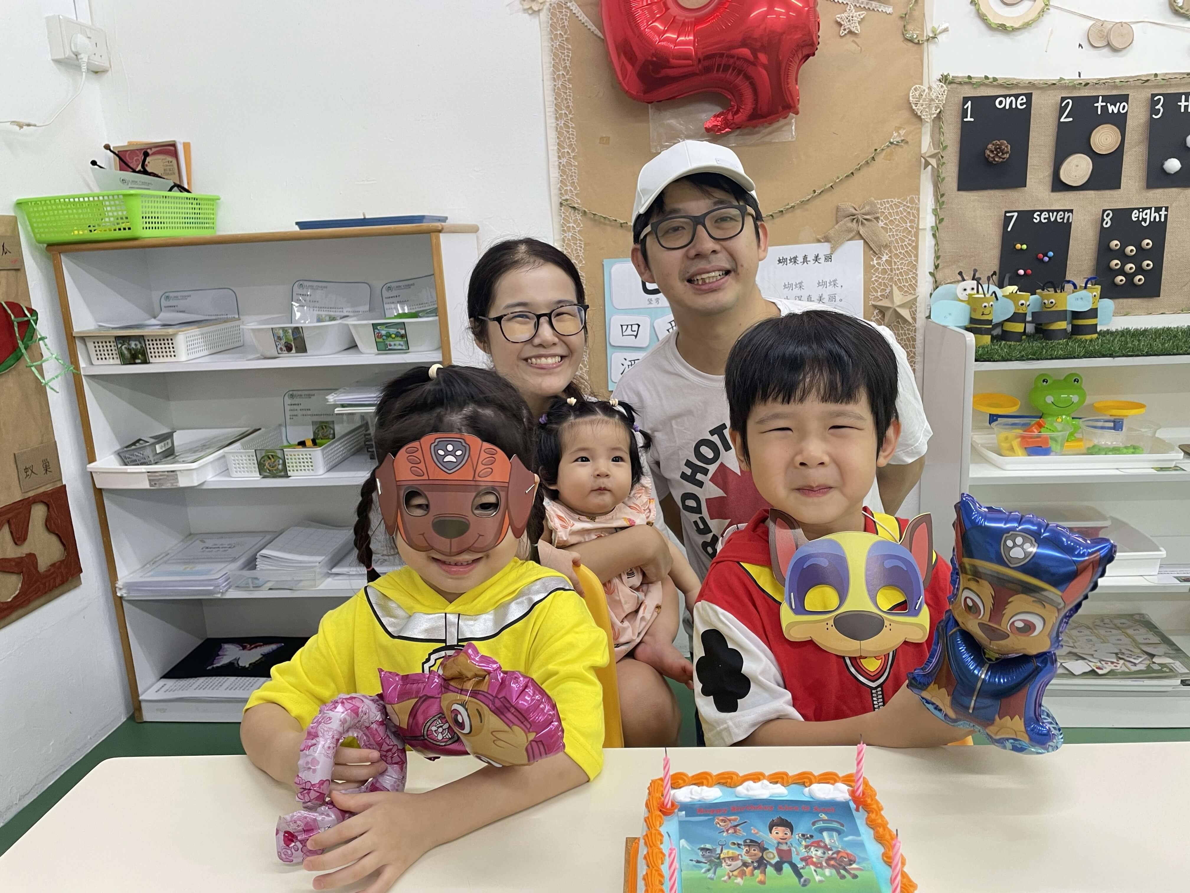 Family photo at a PAW Patrol themed birthday party with twins in costume and baby